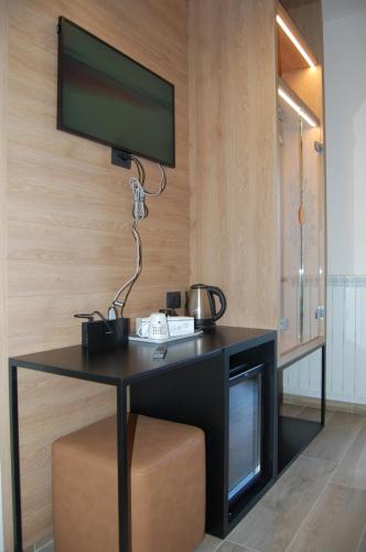 Pokój z biurkiem i telewizorem na ścianie w obiekcie MIRANDOLINA Bed and Breakfast w mieście Rocca di Cambio