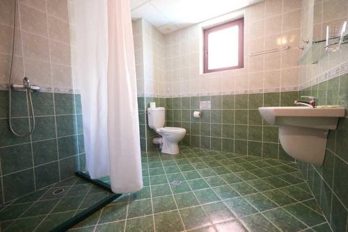 een badkamer met een toilet, een wastafel en een douche bij Hotel Smolyan in Sunny Beach