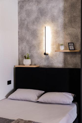 a bedroom with a bed with a black headboard and a lamp at Frourio Lodge A3 in Larisa
