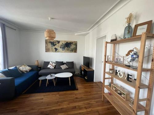 un salon avec un canapé bleu et une table dans l'établissement Au Quai de Seine de Paris appartement- T2, à Vitry-sur-Seine