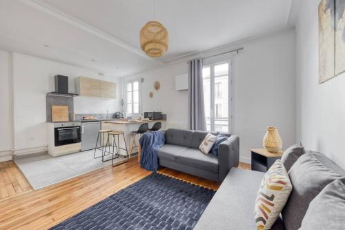 un salon avec un canapé et une cuisine dans l'établissement Au Quai de Seine de Paris appartement- T2, à Vitry-sur-Seine