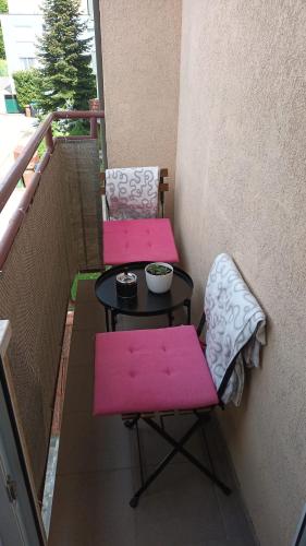two pink chairs and a table on a balcony at kutak in Sesvete