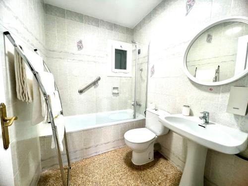 a bathroom with a toilet and a sink and a mirror at Escondite central con terraza compartida en la azotea in Roses
