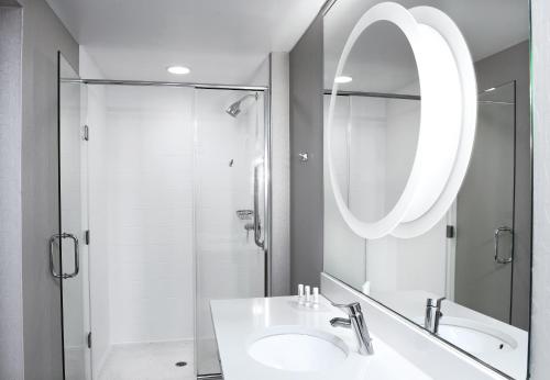 a bathroom with a sink and a shower and a mirror at SpringHill Suites by Marriott Sioux Falls in Sioux Falls