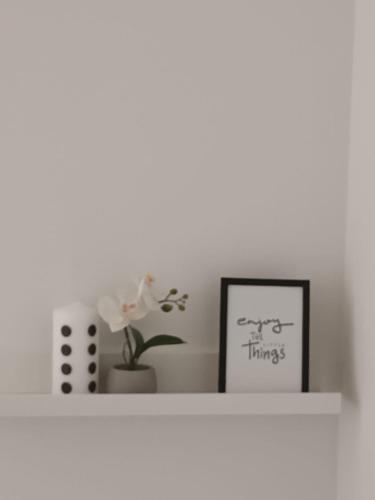 a white shelf with a picture and a plant on it at kutak in Sesvete