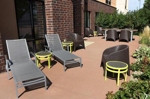a group of chairs and tables and chairs on a patio at SpringHill Suites by Marriott Sioux Falls in Sioux Falls