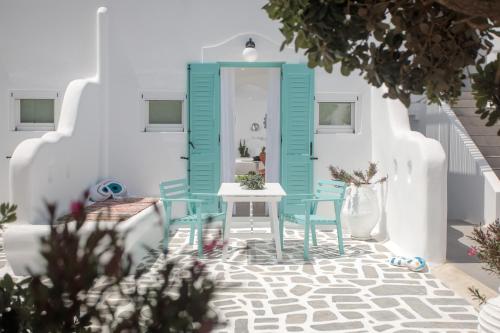 Pokój z niebieskimi drzwiami oraz stołem i krzesłami w obiekcie Naxos Cave Suites w mieście Stelida