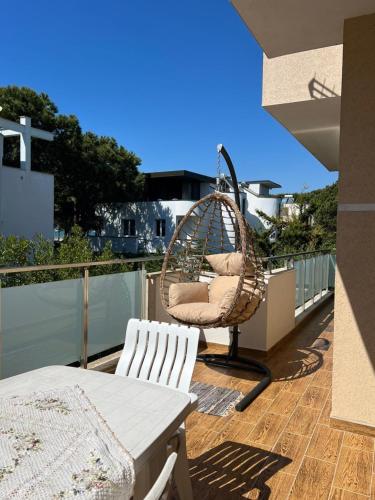 a patio with a swing chair on a balcony at All Seasons Villa 2, Kompleksi Dielli in Golem