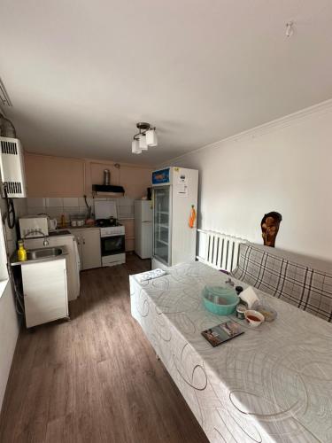 um quarto com uma cozinha com uma cama em Dos Guesthouse em Bishkek