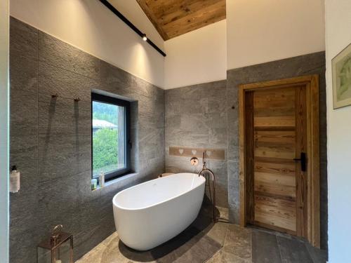 une baignoire dans une salle de bain avec une fenêtre dans l'établissement Chalet 8 Etoiles, à Chamonix-Mont-Blanc