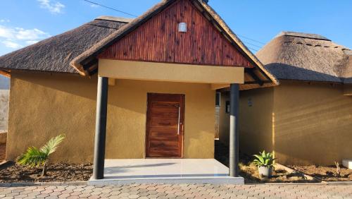 a small house with a thatched roof at Koluti Apartments in Ndola