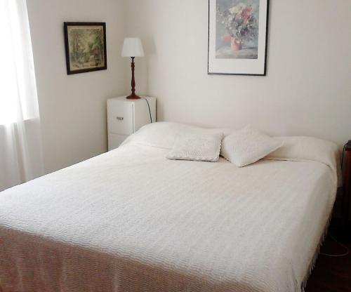 - un lit blanc avec 2 oreillers dans l'établissement Cozy cottage in Aleklinta, north of Borgholm, close to the sea, à Borgholm