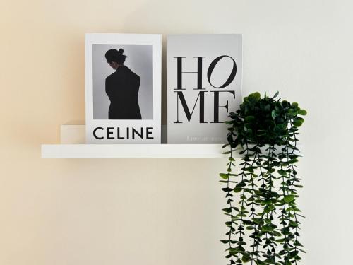 a white shelf with two pictures and a plant at Lynhomes The Establishment Bangsar KL City Sentral Modern Studio Loft in Kuala Lumpur