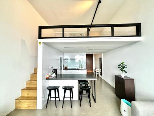 a loft conversion of a house with a kitchen and stools at Lynhomes The Establishment Bangsar KL City Sentral Modern Studio Loft in Kuala Lumpur