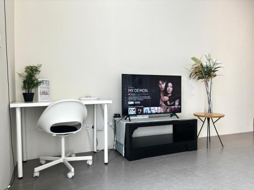 a room with a chair and a tv on a table at Lynhomes The Establishment Bangsar KL City Sentral Modern Studio Loft in Kuala Lumpur