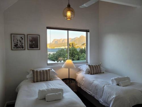 Duas camas num quarto com uma janela em Spacious Central Apartment em Stellenbosch