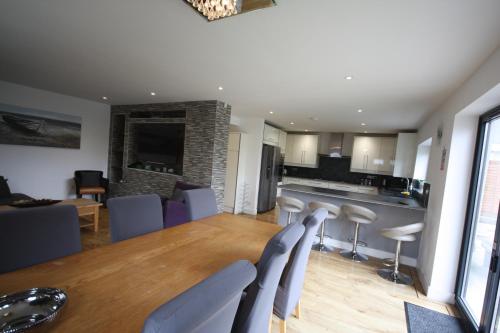 une cuisine et une salle à manger avec une table et des chaises dans l'établissement Four Corners Holiday Home Hot Tub & Sauna, à Ferndown