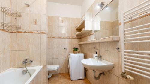 La salle de bains est pourvue d'un lavabo, de toilettes et d'une baignoire. dans l'établissement UrbanElegance Escape, top location, private parking, à Bratislava