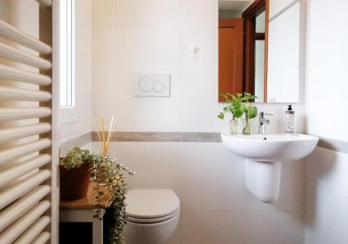 La salle de bains blanche est pourvue de toilettes et d'un lavabo. dans l'établissement HoliHome_Casa di Sara, à Tortoreto Lido