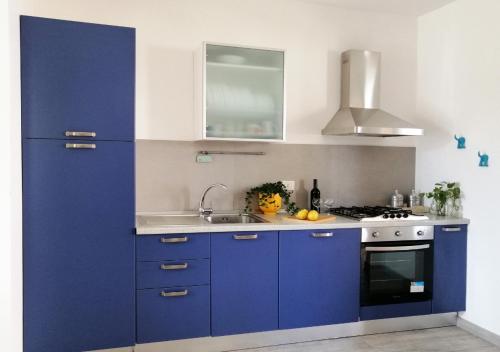una cucina con armadi blu e frigorifero blu di HoliHome_Casa di Sara a Tortoreto