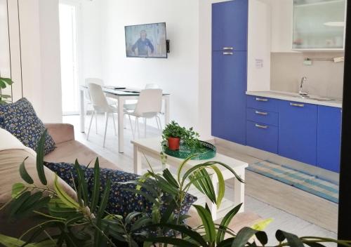 un soggiorno con mobili blu e un tavolo con piante di HoliHome_Casa di Sara a Tortoreto