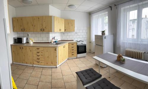 a kitchen with wooden cabinets and a refrigerator and a table at Ubytování U Ropáků in Horní Slavkov