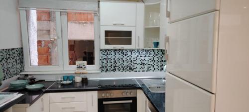 a kitchen with white cabinets and a white refrigerator at Župski TRG in Aleksandrovac