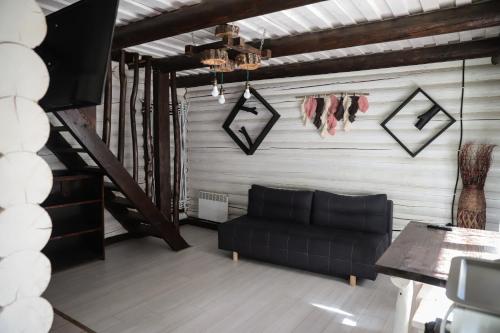 - un salon avec un canapé noir et une table dans l'établissement База відпочинку Forest Stream, à Svalyava