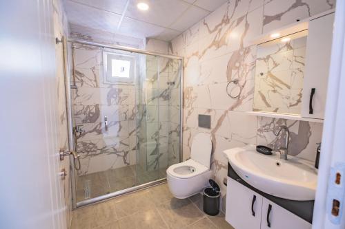 a bathroom with a shower and a toilet and a sink at Gökkuşağı Pansiyon in Kaş