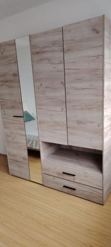 a wooden dresser with two mirrors in a room at Župski TRG in Aleksandrovac