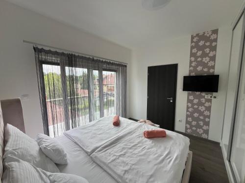 een slaapkamer met een bed en een groot raam bij Smeraldo Penthouse Zamardi in Zamárdi