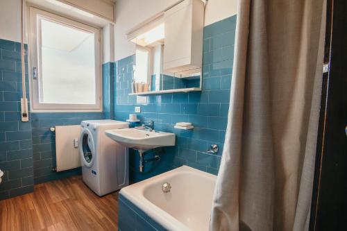 a blue bathroom with a sink and a washing machine at Three Lakes - Lakeside SRL L&B in Massino Visconti