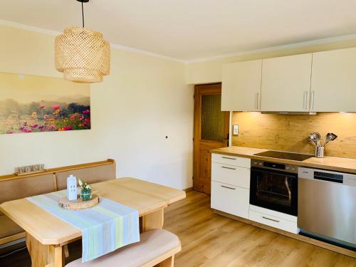 eine Küche mit weißen Schränken und einem Holztisch in der Unterkunft Ferienwohnung Stadlmann in St. Wolfgang