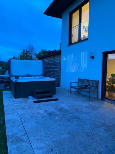 a backyard with a pool and a bench next to a house at Luxus-Anwesen mit Charme in Koblach