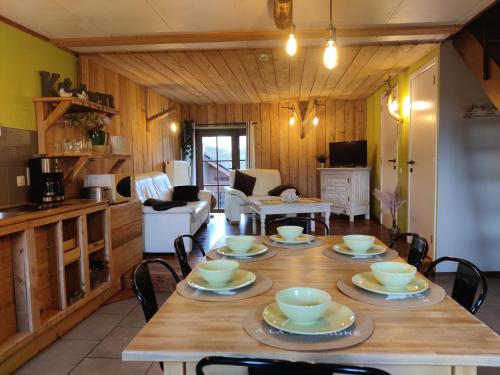 una sala da pranzo con tavolo e sedie e una cucina di La Ferme du Pré Charmant a Grandhan