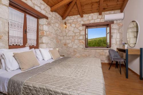 a bedroom with a bed and a desk and a window at Villa Luciana by Villa Plus in Koiliomenos