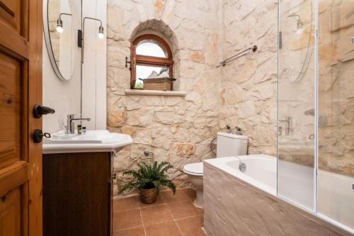 a bathroom with a sink and a tub and a toilet at Villa Luciana by Villa Plus in Koiliomenos