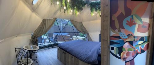 een slaapkamer met een bed in een tent bij La Ferme 1851 - Cabane Spa Nordique privé vue sur champ 