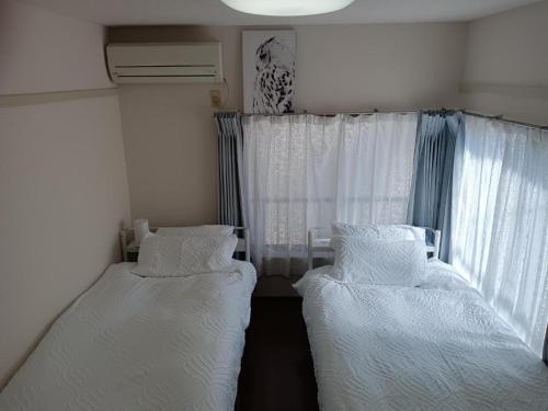 2 camas en una habitación pequeña con ventana en Tokyo downtown, en Tokio