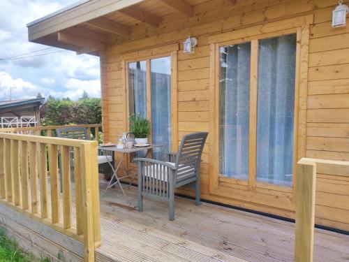 a wooden cabin with a table and chairs on a deck at Rêves & Rivière in Rivière