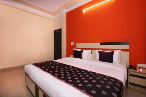a bedroom with a large bed with an orange wall at Hotel Parkash Inn in Jalandhar