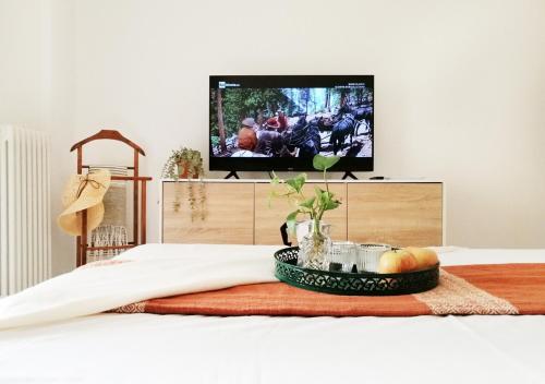 un vassoio di frutta su un letto con televisore di HoliHome_Colombo - Open Space, 100m dal mare! a Tortoreto