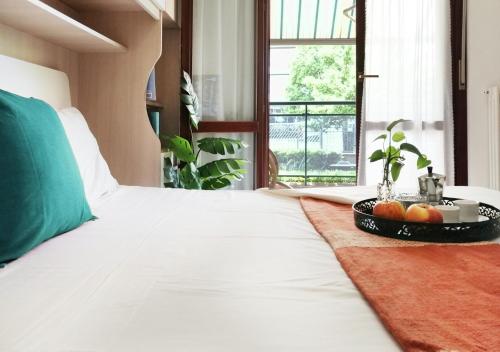 un letto bianco con un vassoio di frutta sopra di HoliHome_Colombo - Open Space, 100m dal mare! a Tortoreto