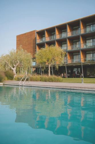 a swimming pool in front of a building at Hotel Terraverda at Empordà Golf Resort in Torroella de Montgrí