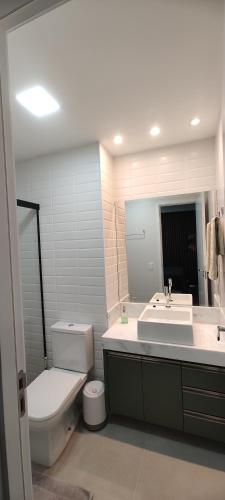 a bathroom with a sink and a toilet and a mirror at 2403 apartamento Setor Oeste gyn in Goiânia