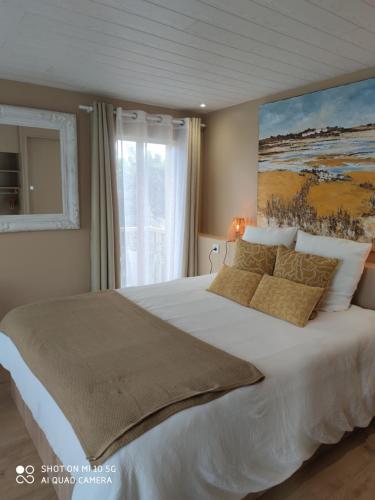 a bedroom with a large bed with a painting on the wall at Rêves & Rivière in Rivière