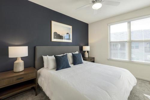 a bedroom with a large white bed with blue pillows at Landing at 99 Front - 2 Bedrooms in Downtown Memphis in Memphis