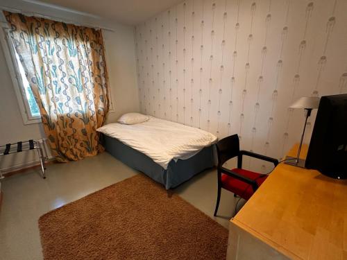 a small bedroom with a small bed and a chair at Grand Hostel Imatra in Imatra