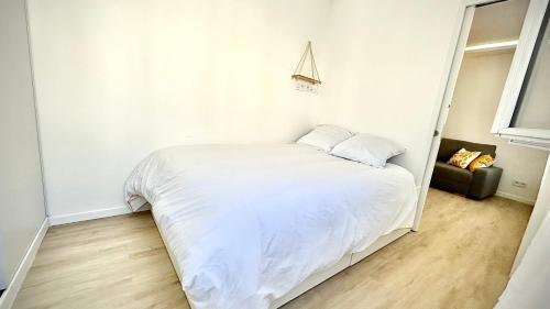 a bedroom with a white bed and a couch at Nouvel appart cosy, centre Tours in Tours