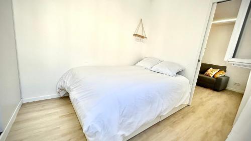 una camera da letto con un letto bianco e un divano di Nouvel appart cosy, centre Tours a Tours